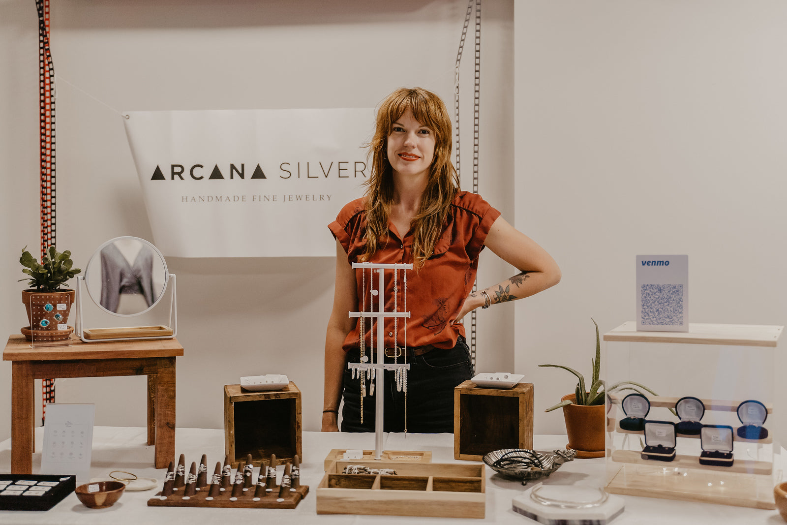 Goldsmith Jenna Bantjes behind her booth at a trade show event.